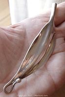 Image of sterling silver hair ornament clip held in palm, showing overall shape and loop end.