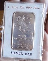 Front of silver bar showing embossed bell design and anniversary text with Serial: 1992, in clear plastic case with hinges.