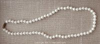 Full-length view of pearl strand laid flat to show overall length and uniformity