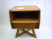 Front view of nightstand showing open shelf and closed drawer atop X-shaped leg base