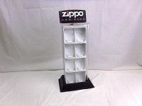 Front view of the Zippo lighter store display with the brand sign and compartments for holding lighters.