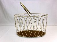 Front and side view of the gold-tone metal magazine holder with wooden base, showing foldable metal handle.