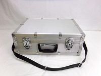 Closed view of the rectangular aluminum camera case showing metal clasps, black handle, and attached black shoulder strap on a white background.