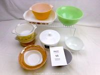 Photo showing all glass bowls and containers, including 2 vintage Pyrex bowls with lids and various other glass pieces in orange, green, and white.