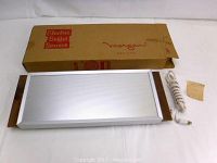 Full view of the electric food warmer laid out next to its original box and power cord, showing the aluminum warming surface and wooden handles.