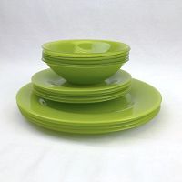 Stacked view of green glass bowls, sandwich plates, and dinner plates in a pile.
