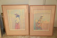 Two pastel pointillism prints leaning against a wall. The left one is framed, the right one is unframed.
