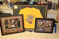 Overview photo of all three framed items: yellow Kobe Bryant Lakers signed t-shirt, NY Giants Super Bowl collage, and The Sopranos framed art