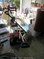 Overview of Toro electric snow shovel and manual snow shovels in garage.