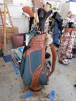 Full view of green and brown Daiwa golf bag standing upright with golf clubs inside, showing shape, materials and storage compartments.