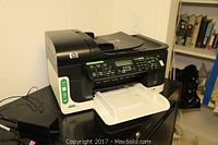 HP Officejet 6500 Wireless all-in-one printer shown sitting on a black surface with open paper tray