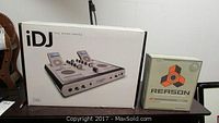 Photo showing Ion iDJ iPod mixing console packaging and Reason software box side by side on a table.