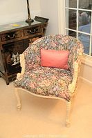Side angle view of the upholstered chair showing floral fabric and rope-wrapped arm and leg details