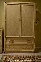 Front view of the Thomasville armoire showing two doors and two drawers with metal handles.