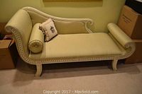 Front view of upholstered chaise lounge with two pillows, showing seat and frame details