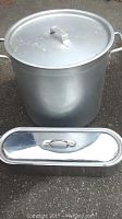 Photo of XL steel cooking pot with lid and fish steamer pot in front of it, showing full height and shape