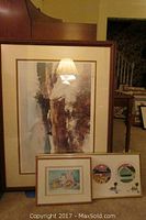Large framed abstract landscape-style print leaning against furniture.