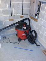 Front angle of Craftsman shop vac with attached hose and long black plastic extension wand resting beside it.