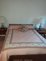 Full view of the Willett mid-century modern queen bed with bedding and pillows, showing the headboard and the sides of the bed.