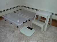 Full view of the entire lot including two wheeled plastic storage bins, plastic step-stool, and Health-o-meter bathroom scale on carpet.