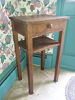 Full view of oak side table with drawer and lower shelf, showing straight legs and wooden knob on drawer.