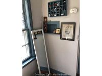 Tall mirror leaning against wall beside window