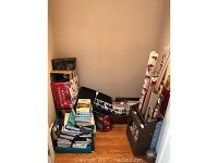 Full closet space with stacks of books, rolls of wrapping paper, and organizational racks visible.
