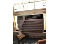 Front view of GE window air conditioner installed in window with visible control panel and front airflow grille.