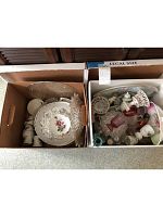 Two boxes filled with assorted china and glassware items as seen from top view.