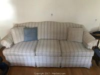 Front-facing view of the sofa showing the full seating area and throw pillows.