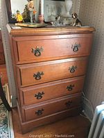 First vintage highboy dresser with four drawers, metal ornate handles, light age wear visible on wood surface.