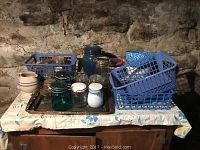 Overview of assorted jars on a table with blue plastic baskets and ceramics