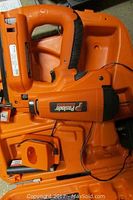 Orange Paslode cordless 16 gauge finish nailer in orange plastic carrying case, showing tool body and case interior.