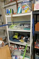 Four-shelf plastic storage unit with paint supplies, tools, and containers
