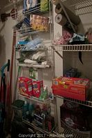 Shelves with cleaning supplies including Brillo pads, detergents, garbage bags, and other household cleaning items.