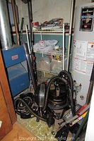Rainbow vacuum cleaner with hoses and accessories in basement near furnace and water heater