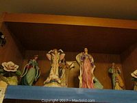 Shelf view of five Lenox princess figurines