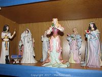 Shelf display showing multiple Lenox princess figurines with varied costumes and poses