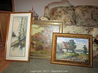 Three framed paintings leaning against a floral couch, showing detailed views of each artwork and their frames.
