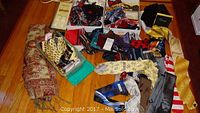 Overview photo showing multiple bow ties, neckties, and handkerchiefs spread out along with a fabric covered box containing more items.