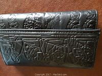 Close-up photo of the wallet exterior showing embossed Middle Eastern figures and patterns.