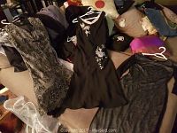 Photo of three dresses including the black embroidered dress and black over white slip showing original condition and details.