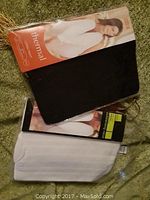 Photo showing black long-sleeve thermal top in packaging with visible model image and 'thermal' text.