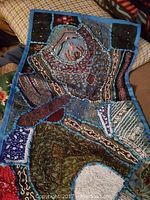 Close-up of upper section showing patchwork panels, embroidery and bead details