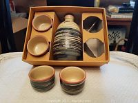 Photo of ceramic sake bottle and four matching cups in original box with cardboard insert.