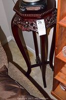 Full photo of the decorative wood stand table with flower carvings and marble top in room corner
