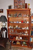 Photo showing full front of oak bookcase filled with various decorative items (not included) and showing the bookcase's appearance and size.