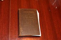 Closed view of 1929 Book of Common Prayer showing worn brown hardcover with embossed cross and title.