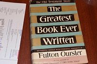 Photo showing the front cover and spine of the hardcover book with the dust jacket that reads 'The Greatest Book Ever Written' by Fulton Oursler.