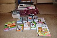 Main overview showing Cricut Expression machine, pink/brown carrying case and white Jukebox unit on carpet